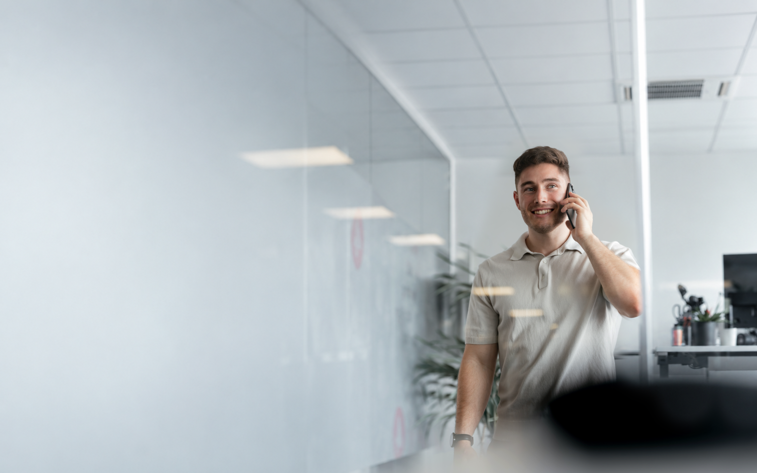 Niko telefoniert in einem hellen Büro